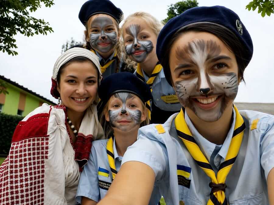 Вовченята з розмальованими мордочками вовка разом із провідницею